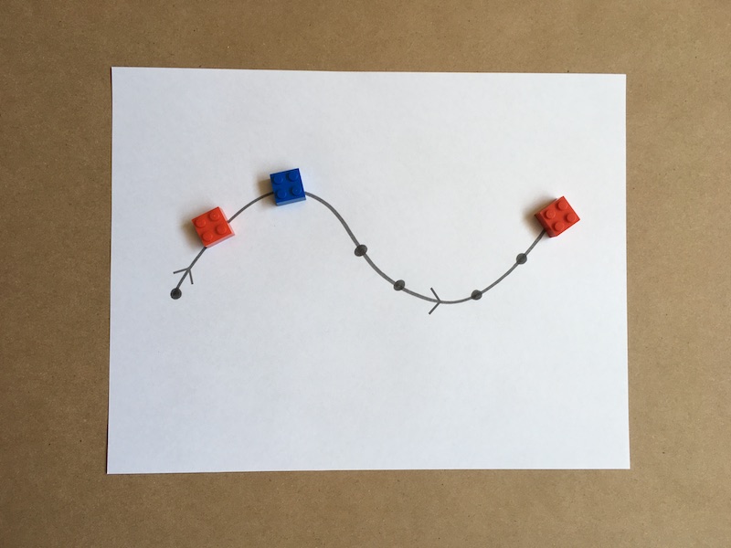 An arrangement of red and blue pieces on a curvy line