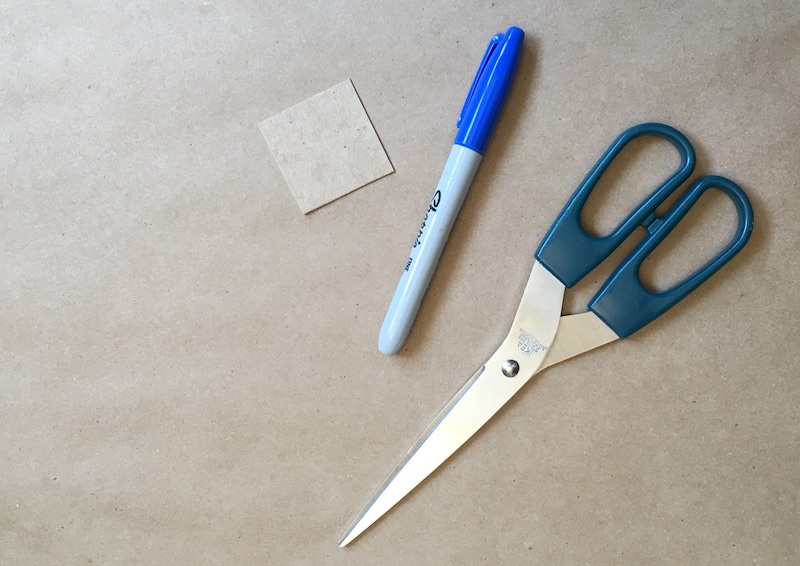 Square of cardboard, a marker, and scissors