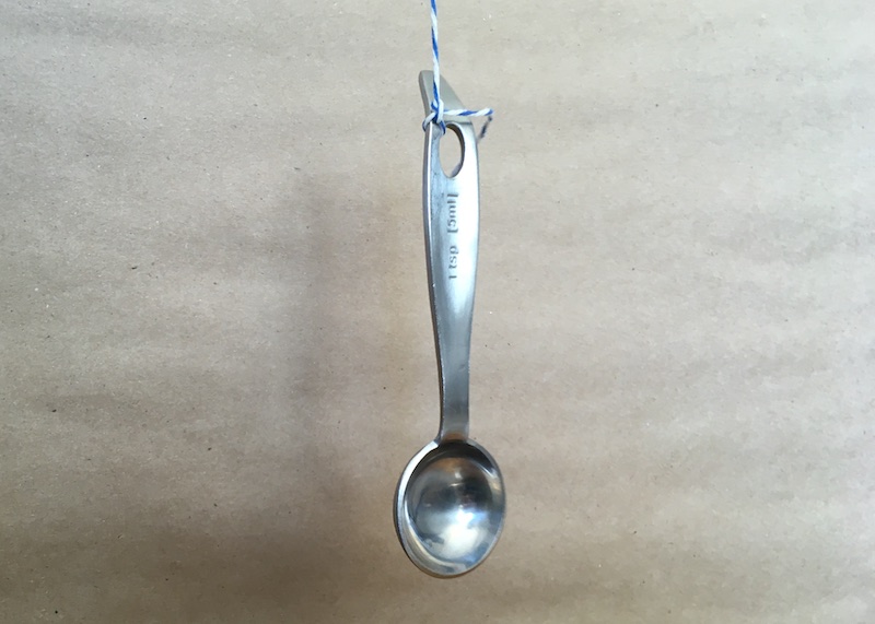 A measuring spoon tied to string