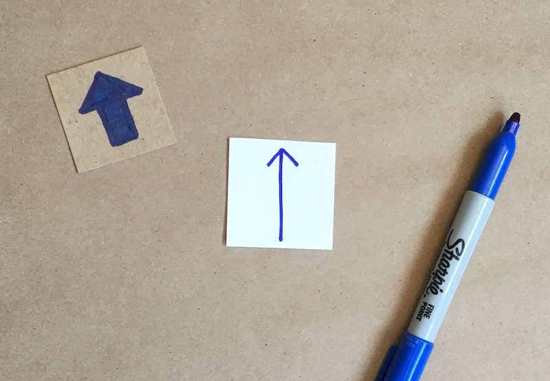 An arrow drawn on a square of paper
