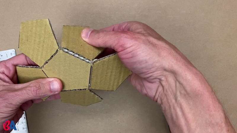 Folding over the scored pentagons