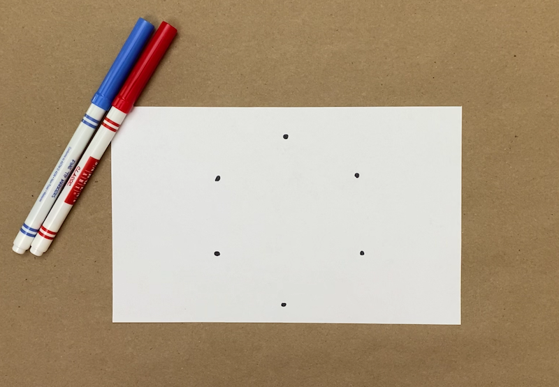 Six dots drawn on a piece of paper