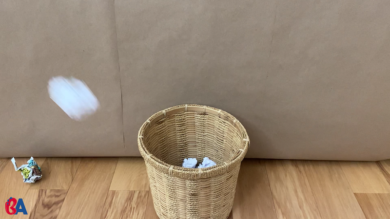 Paper ball being thrown in a waste basket