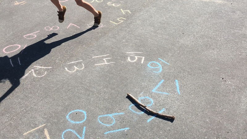 A stick set on a number while a kid jumps