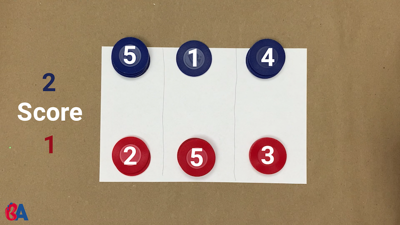 Paper divider set up between red and blue tokens